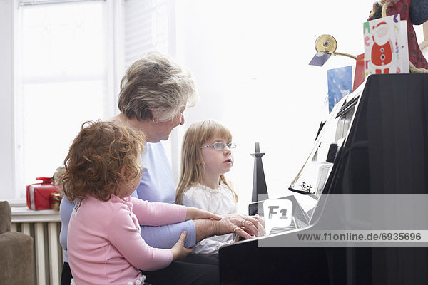 Woman Playing Piano with Granddaughters
