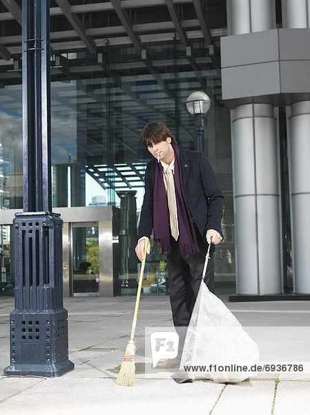 Man Sweeping Up Outside Building