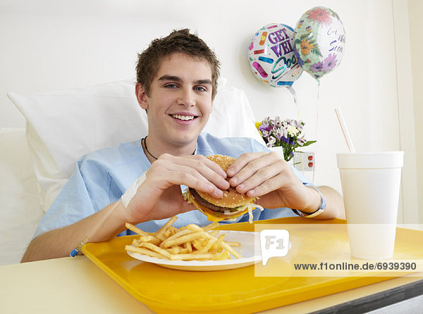 Boy Eating Burger in Hospital Room