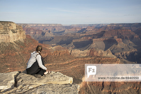 Woman Sitting on Rock  Overlooking Grand Canyon  Arizona  USA