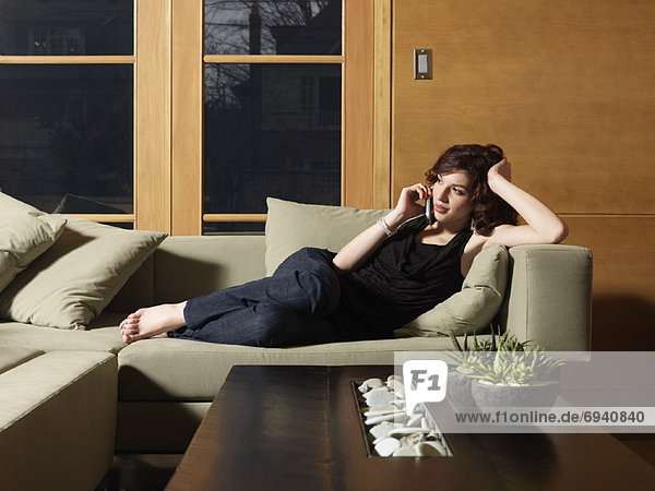 Woman Lying on Sofa  Using Cell Phone