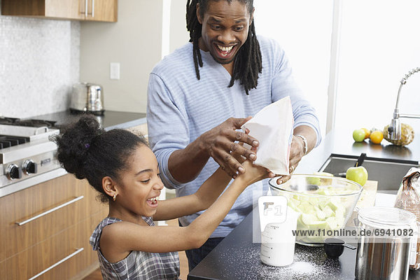 Father and Daughter Making Applesauce in Kitchen