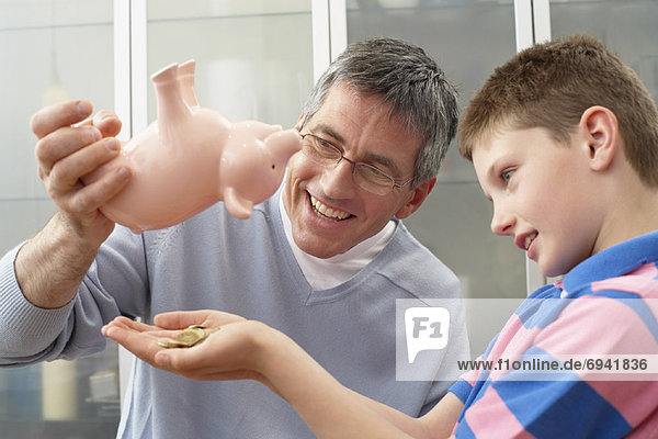 Father and Son With Piggy Bank