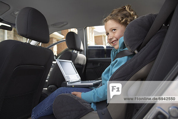 Girl with DVD Player  Sitting in Back Seat of Car