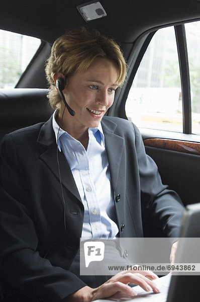 Geschäftsfrau mit Laptop im Auto