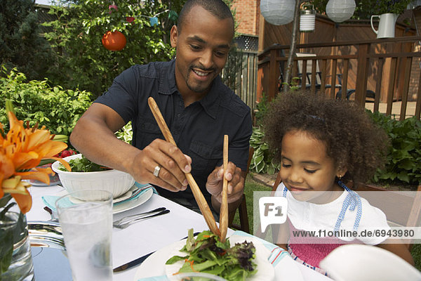 Father and Daughter Eating Outdoors