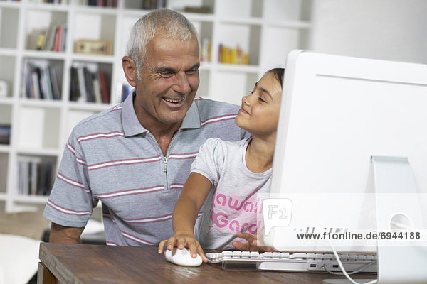 Grandfather and Granddaughter Using Computer