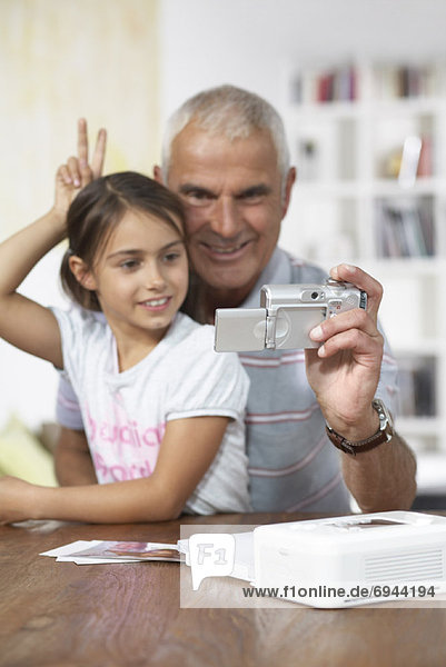 Grandfather and Granddaughter With Digital Camera