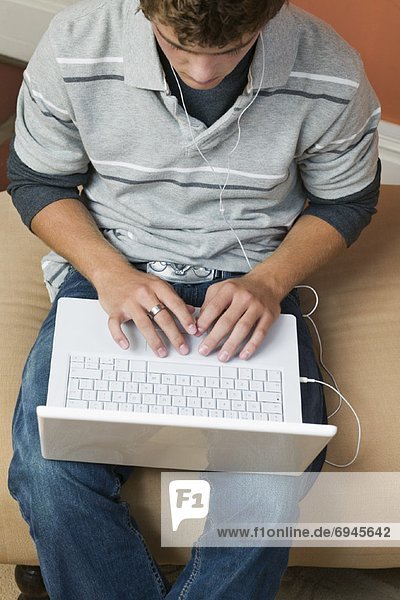 männlicher Teenager mit Laptop