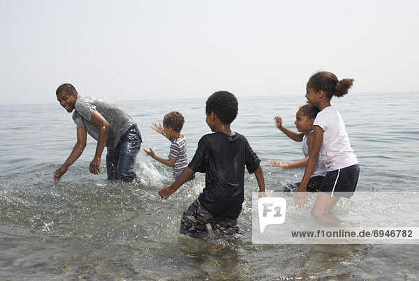 Children Splashing Man in Lake