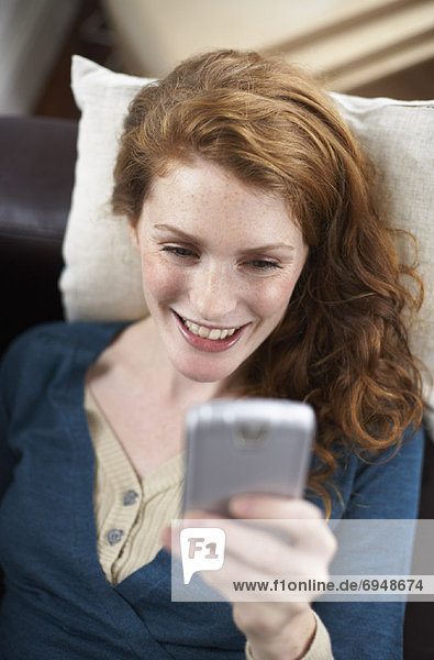 Woman with Electronic Organizer on Sofa
