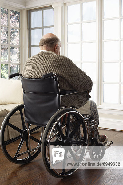 Senior Man in Wheelchair  Looking Out Window