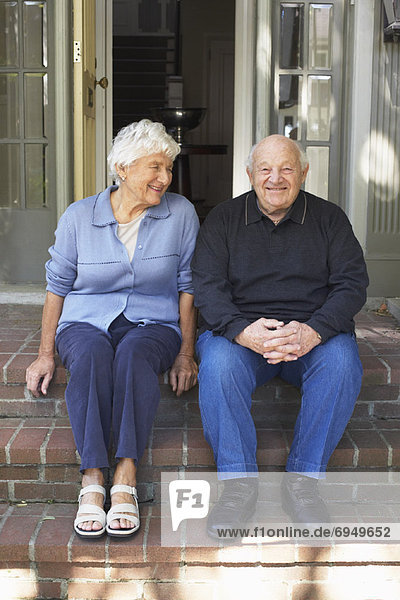 Portrait of Senior Couple Sitting on Doorstep