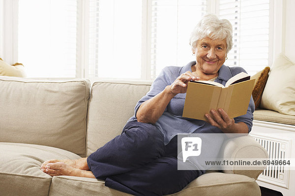 sitzend Senior Senioren Frau Couch Buch Taschenbuch vorlesen