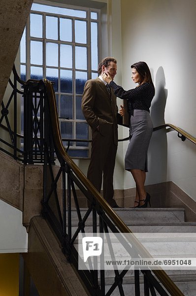 Businessman and Woman Flirting in Stairwell
