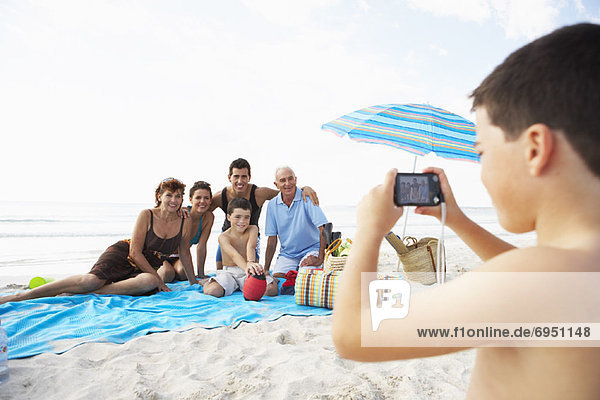 Boy Taking Photo of Family on the Beach