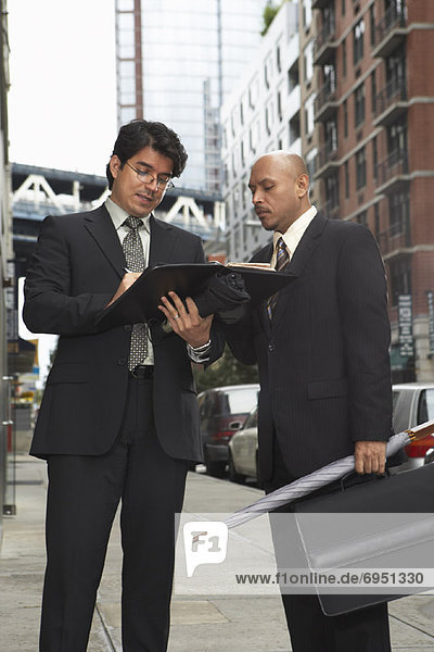 Businessmen on Sidewalk Looking at Files  New York City  New York  USA