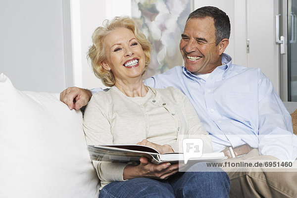Couple with Book on Sofa