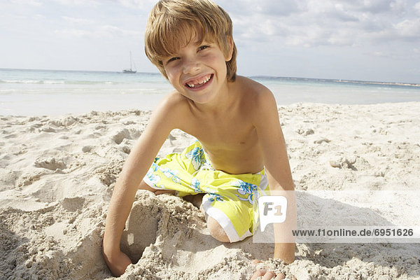 Boy Digging in Sand on Beach  Majorca  Spain