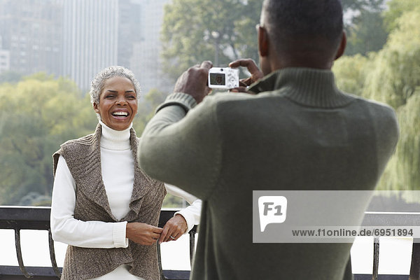 Man Taking Picture of Woman by Water New York City New York USA
