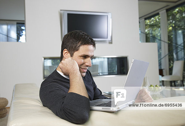 Man in Living Room with Laptop Computer