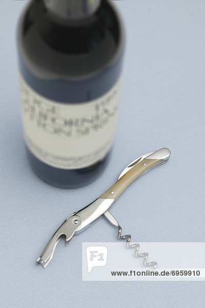Bottle of wine and opener  blue background