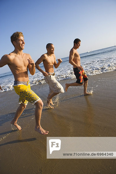 Three Teenage Boys Running on Beach
