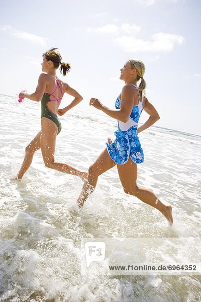 Two Young Women Running in Surf
