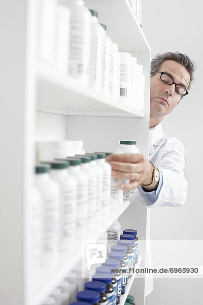 Pharmacist Taking Pills From Shelf