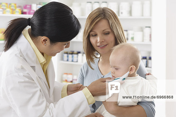 Pharmacist Taking Babys Temperature