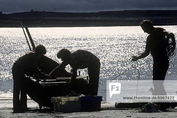 Silhouette Of Fishermen Near The Currach On The Beach  Inishmaan  Aran Islands  Galway Bay  Republic Of Ireland