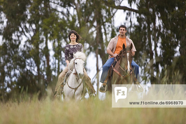 Couple Horseback Riding on Ranch  Santa Cruz  California  USA