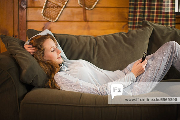 Woman Relaxing on Couch  Listening to MP3 Player
