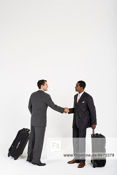 Businessmen With Luggage Shaking Hands