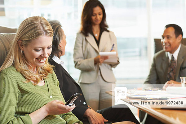 Businesswoman Using Her Cell Phone During Meeting