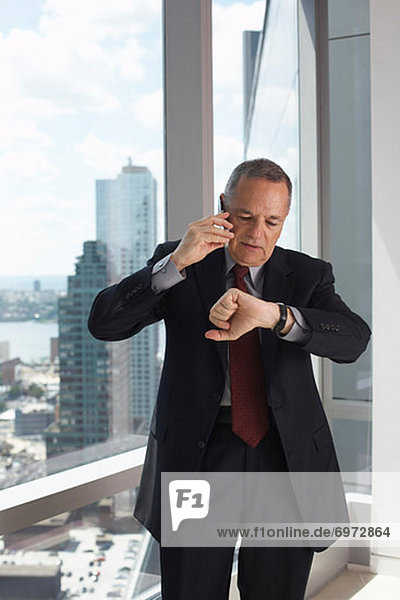 Businessman Talking on Cell Phone  Looking at Watch