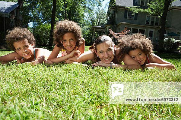 Portrait of Mother and Children Laying on Grass
