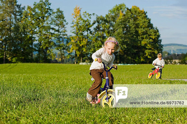 Boy and Girl Riding Bicycles  Salzburger Land  Austria