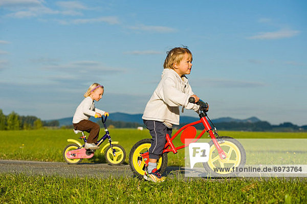 Boy and Girl Riding Bicycles  Hof bei Salzburg  Salzburger Land  Austria