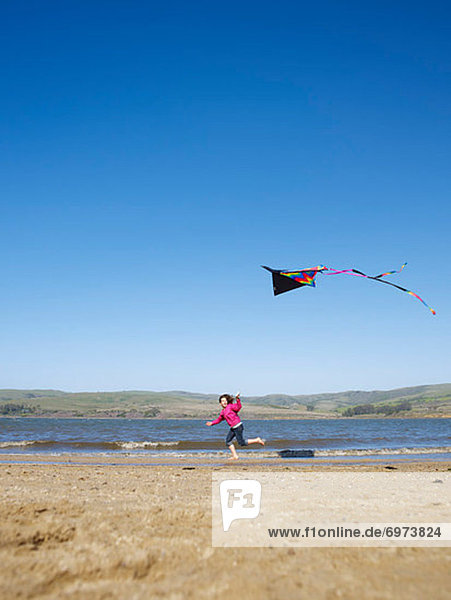 Girl Flying Kite on Beach