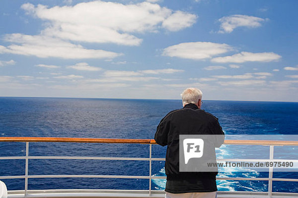 Man Looking Over Railing at Stern of Cruise Ship