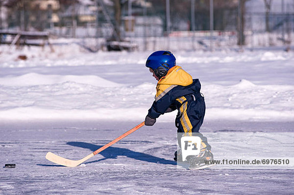 Little Boy Playing Hockey on a Frozen Pond  Fuschlsee  Salzburger Land  Austria