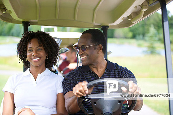 Portrait of Couple Riding in Golf Cart