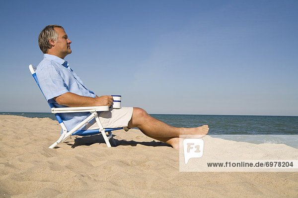 Man Relaxing on the Beach With a Cup of Coffee  Lake Michigan  USA