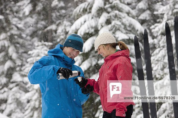 Close-up of Couple Drinking from Thermos,  Cross Country Skiing,  Whistler,  British Columbia,  Canada
