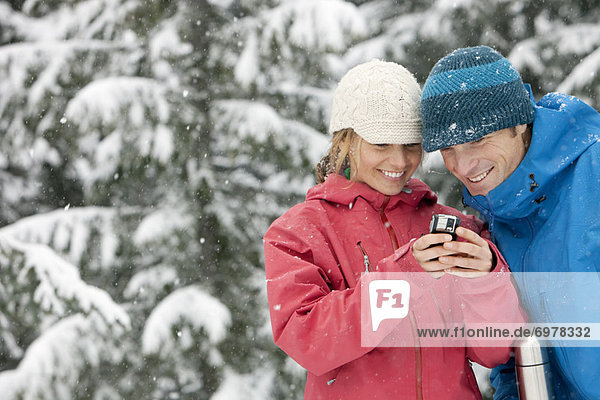 Close-up of Couple Using PDA Outdoors in Winter,  Whistler,  British Columbia,  Canada