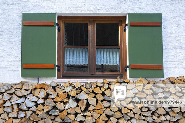 Feuerholz Stapel Bauernhaus Fenster frontal Bayern Berchtesgaden Deutschland alt