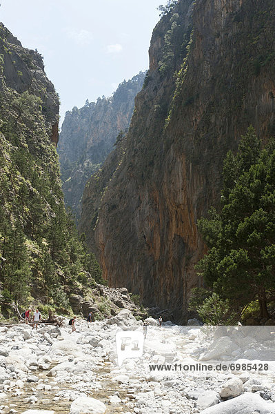 Steep cliffs rise up above the rocky bed of a stream  several hikers  2nd Gate  view towards the south  Samaria Gorge National Park  near Agia Roumeli  Crete  Greece  Europe