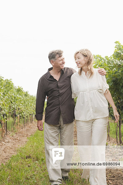 Couple Walking Through Vineyard