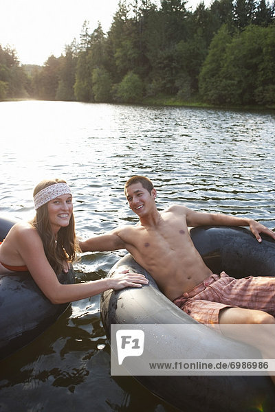 Young Couple Floating on Inner Tubes on the Lake  Near Portland  Oregon  USA